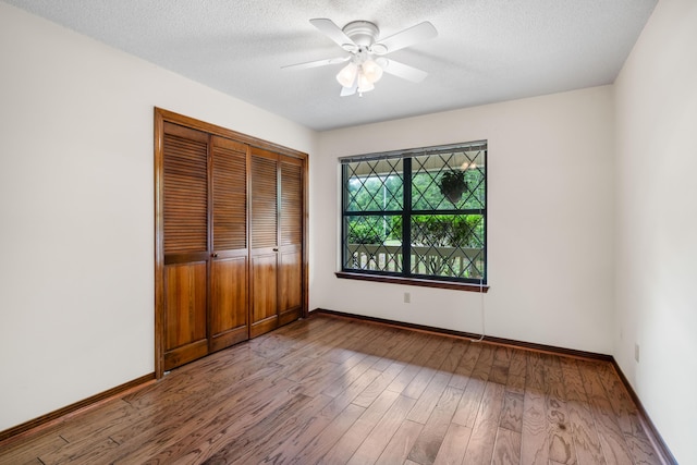 102 Bermuda Way, Niceville, FL 32578 - unfurnished bedroom featuring wood finished floors, baseboards, a closet, a textured ceiling, and ceiling fan
