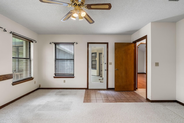102 Bermuda Way, Niceville, FL 32578 - unfurnished room with carpet floors, a ceiling fan, baseboards, a textured ceiling, and tile patterned floors