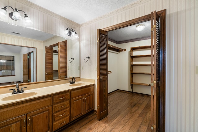 102 Bermuda Way, Niceville, FL 32578 - bathroom featuring a textured ceiling, hardwood / wood-style flooring, wallpapered walls, cooling unit, and double vanity