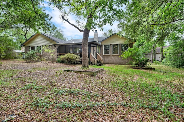102 Bermuda Way, Niceville, FL 32578 - back of house featuring a sunroom, a chimney, and brick siding