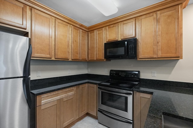 251 Mattie M Kelly Blvd Unit 203, Destin, FL 32541 - kitchen featuring appliances with stainless steel finishes, dark stone countertops, light tile patterned floors, and a sink