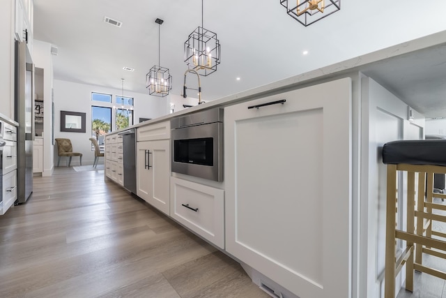 kitchen featuring a chandelier, white cabinetry, and appliances with stainless steel finishes