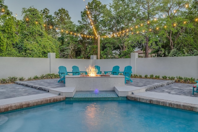 view of pool with a patio, a fire pit, and fence
