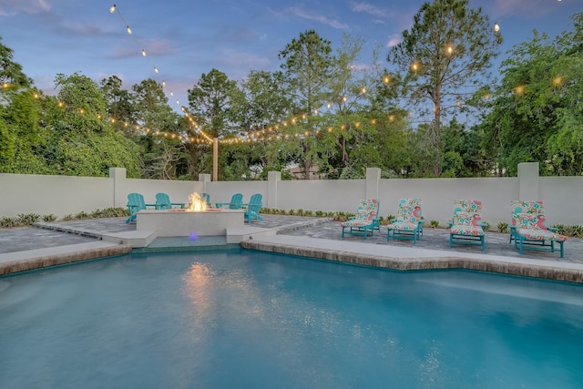 view of pool with a patio, a fire pit, and fence