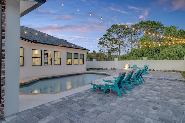 view of swimming pool with a fire pit, a fenced backyard, and a patio area