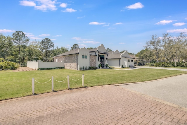 view of front of house with stucco siding and a front lawn