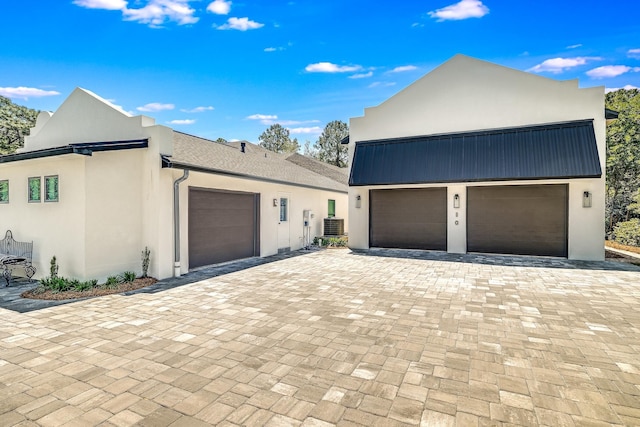 view of side of home with stucco siding and a garage