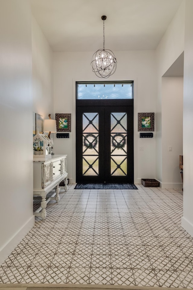 entrance foyer featuring a chandelier and baseboards