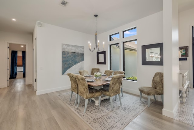 dining area featuring a chandelier, light wood finished floors, baseboards, and recessed lighting