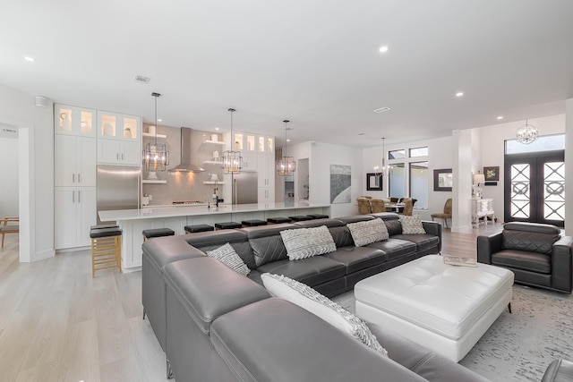 living room featuring a chandelier, light wood finished floors, and recessed lighting