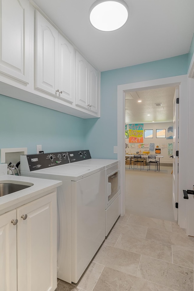 laundry area featuring washing machine and clothes dryer and cabinet space