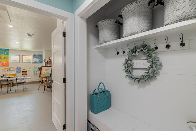mudroom with finished concrete flooring and a textured ceiling