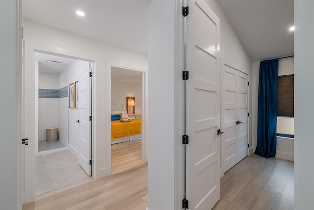 hallway with light wood finished floors, recessed lighting, and baseboards