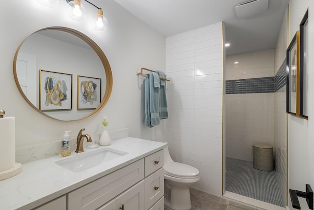 bathroom featuring toilet, tile patterned floors, a walk in shower, and vanity