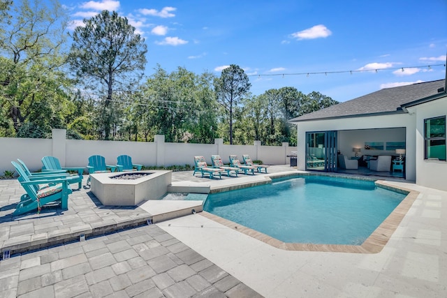 view of swimming pool with an outdoor fire pit, a patio area, and fence
