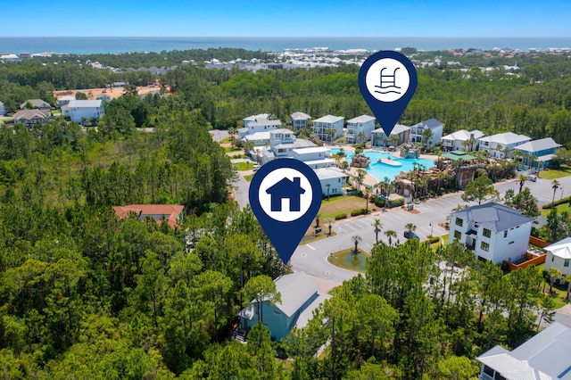 aerial perspective of suburban area with a pool and a forest