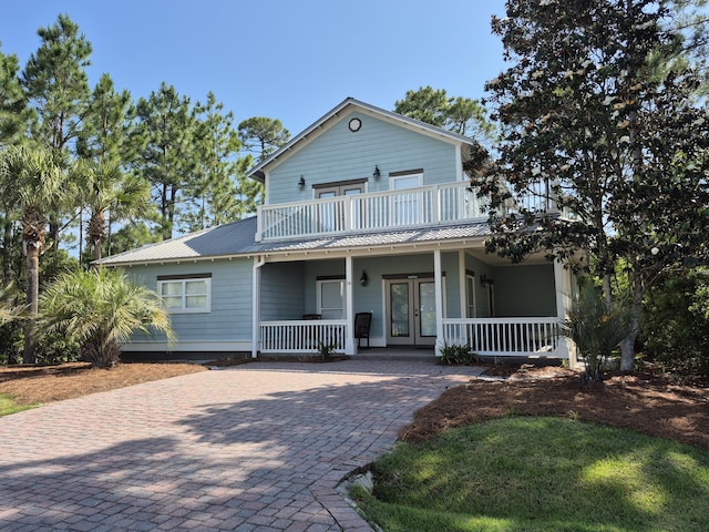 view of front of house with a porch, french doors, metal roof, and a balcony