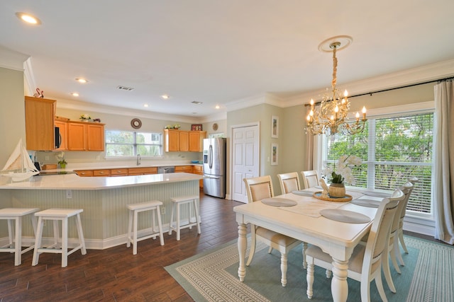 dining area with a chandelier, crown molding, dark wood finished floors, and recessed lighting