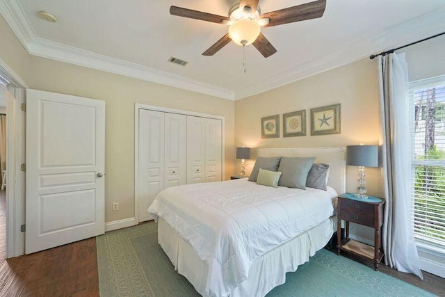 bedroom featuring dark wood-type flooring, a closet, crown molding, baseboards, and ceiling fan