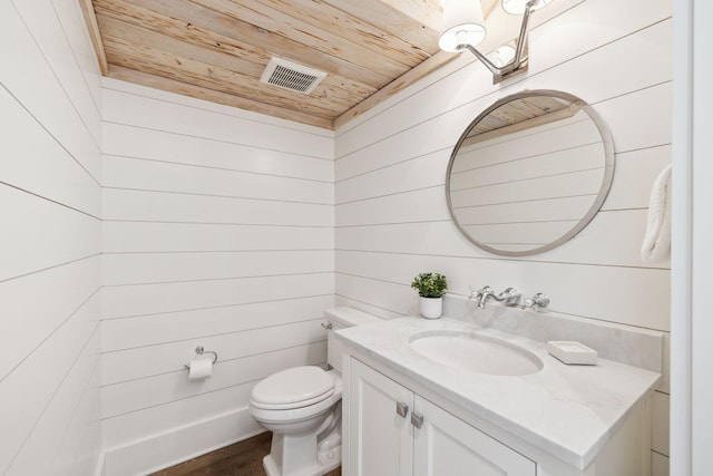 17 Compass Point Way, Watersound, FL 32461 - half bath with wooden ceiling, vanity, toilet, wood walls, and wood finished floors