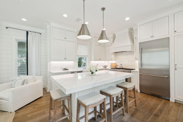 17 Compass Point Way, Watersound, FL 32461 - kitchen with stainless steel appliances, custom range hood, tasteful backsplash, a breakfast bar area, and ornamental molding