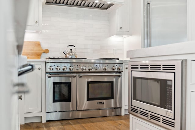 17 Compass Point Way, Watersound, FL 32461 - kitchen with stainless steel appliances, light countertops, exhaust hood, and white cabinetry