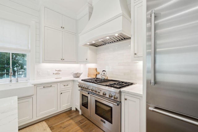 17 Compass Point Way, Watersound, FL 32461 - kitchen featuring high end appliances, custom range hood, a sink, and white cabinetry
