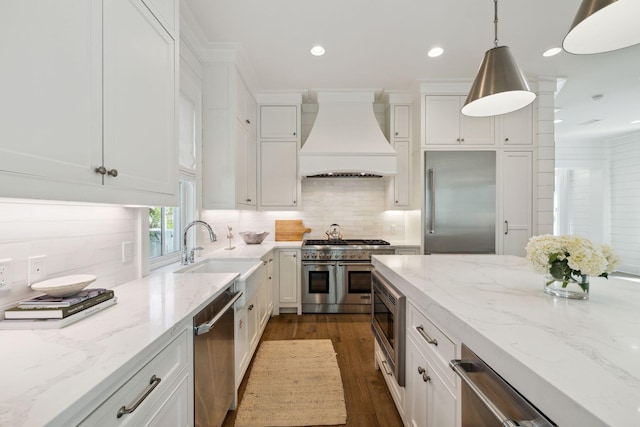 17 Compass Point Way, Watersound, FL 32461 - kitchen featuring built in appliances, custom range hood, a sink, dark wood finished floors, and white cabinets