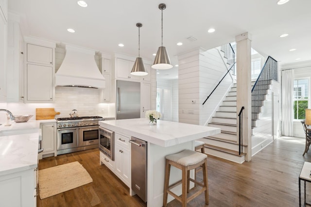 17 Compass Point Way, Watersound, FL 32461 - kitchen with custom exhaust hood, built in appliances, white cabinetry, tasteful backsplash, and dark wood finished floors
