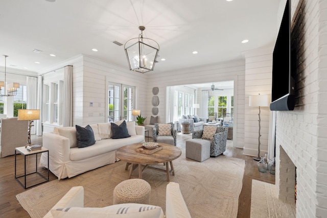 17 Compass Point Way, Watersound, FL 32461 - living area featuring a chandelier, a fireplace, wood finished floors, crown molding, and recessed lighting
