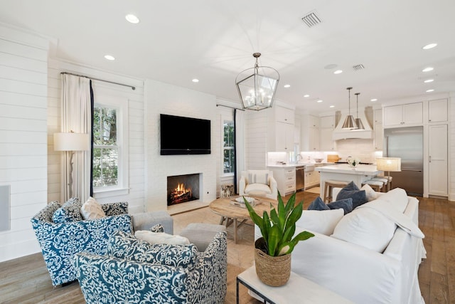 17 Compass Point Way, Watersound, FL 32461 - living area with wood finished floors, recessed lighting, a large fireplace, and a chandelier