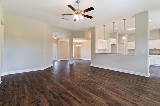 unfurnished living room featuring dark wood-style floors, ceiling fan, a chandelier, baseboards, and recessed lighting