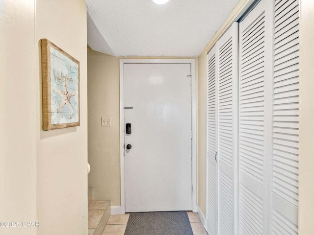 23223 Front Beach Rd Unit A114, Panama City Beach, FL 32413 - entryway featuring light tile patterned floors, a textured ceiling, and baseboards