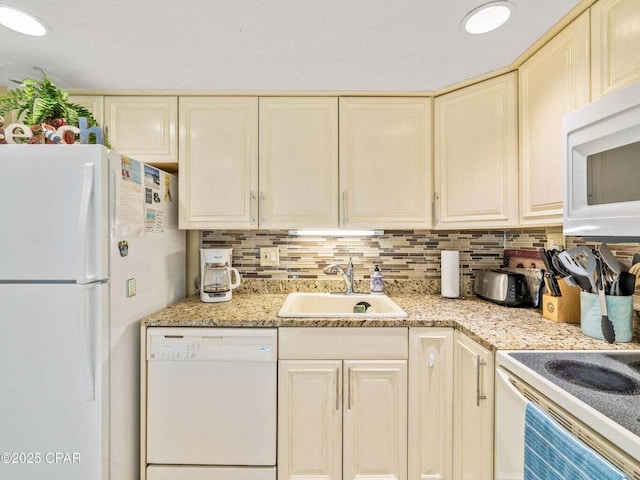 23223 Front Beach Rd Unit A114, Panama City Beach, FL 32413 - kitchen with white appliances, a sink, cream cabinets, tasteful backsplash, and light stone countertops