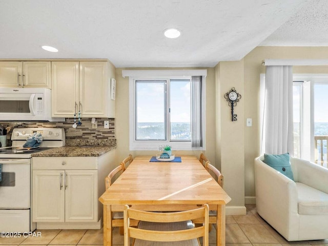 23223 Front Beach Rd Unit A114, Panama City Beach, FL 32413 - kitchen featuring white appliances, light tile patterned floors, decorative backsplash, a textured ceiling, and baseboards