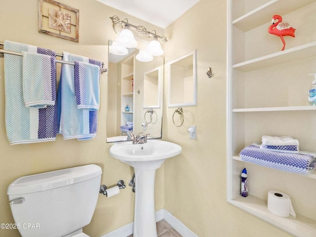 23223 Front Beach Rd Unit A114, Panama City Beach, FL 32413 - bathroom featuring toilet, built in shelves, a sink, baseboards, and tile patterned floors