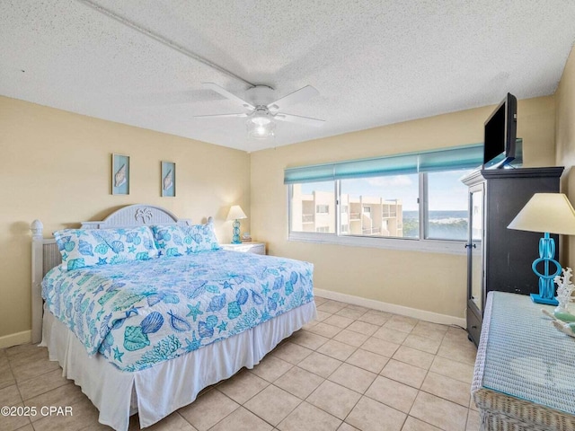 23223 Front Beach Rd Unit A114, Panama City Beach, FL 32413 - bedroom with baseboards, light tile patterned floors, ceiling fan, and a textured ceiling