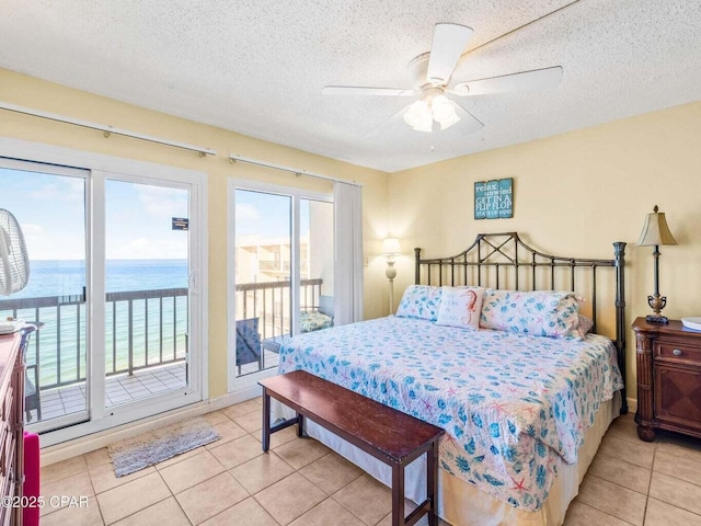 23223 Front Beach Rd Unit A114, Panama City Beach, FL 32413 - bedroom featuring access to outside, light tile patterned flooring, a water view, a textured ceiling, and a ceiling fan