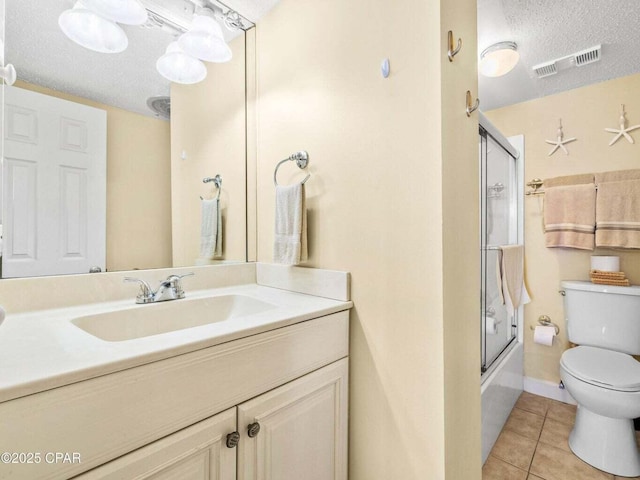 23223 Front Beach Rd Unit A114, Panama City Beach, FL 32413 - full bath with toilet, tile patterned floors, a textured ceiling, vanity, and bath / shower combo with glass door