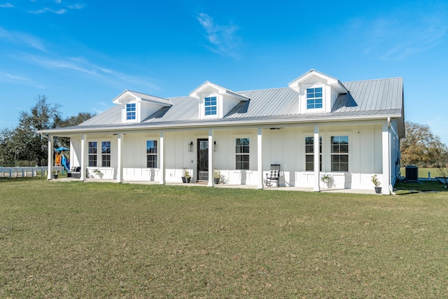 view of front of property featuring board and batten siding, metal roof, and a front lawn