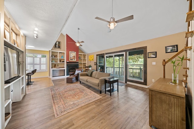439 Big Cedar Rd, Ponce De Leon, FL 32455 - living area featuring a ceiling fan, a fireplace, built in features, wood finished floors, and high vaulted ceiling