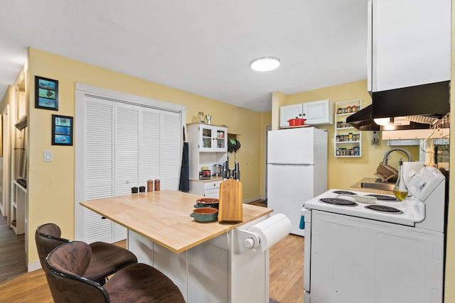 439 Big Cedar Rd, Ponce De Leon, FL 32455 - kitchen with white appliances, light wood-style flooring, island exhaust hood, white cabinets, and a sink