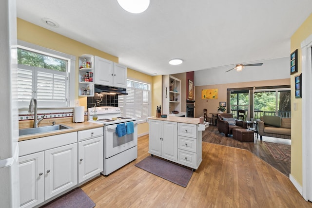 439 Big Cedar Rd, Ponce De Leon, FL 32455 - kitchen featuring white range with electric stovetop, a sink, under cabinet range hood, light wood-type flooring, and open floor plan