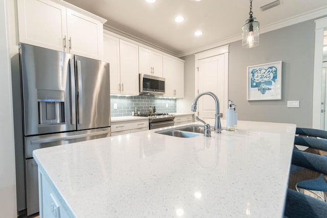 105 Somersault Ln, Inlet Beach, FL 32461 - kitchen with stainless steel appliances, ornamental molding, a center island with sink, backsplash, and white cabinetry