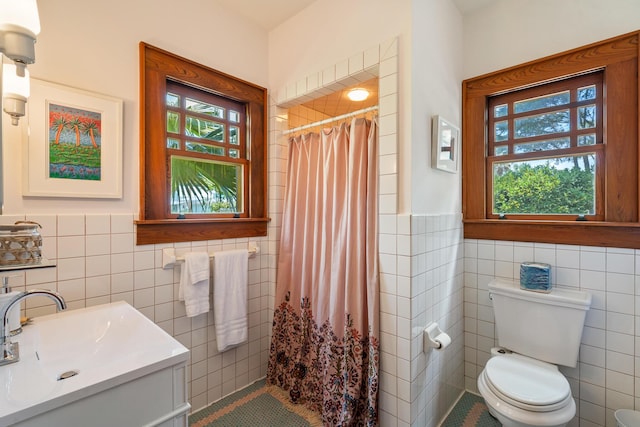25 17th St, Apalachiacola, FL 32320 - bathroom featuring tile walls, wainscoting, toilet, tiled shower, and tile patterned flooring