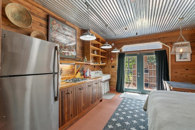 25 17th St, Apalachiacola, FL 32320 - bedroom featuring freestanding refrigerator, french doors, wood walls, finished concrete flooring, and access to exterior