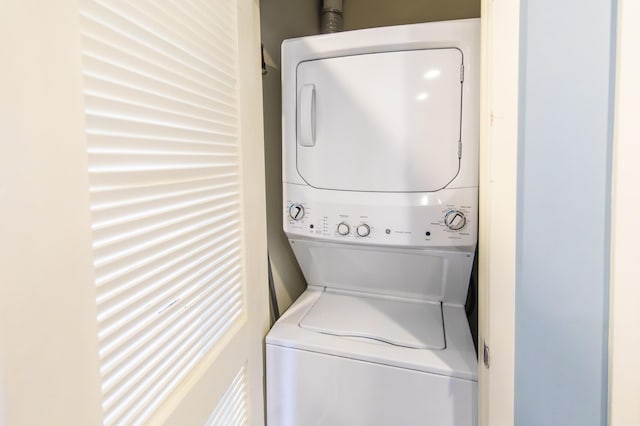 clothes washing area with stacked washer / dryer