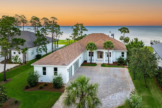 1341 Driftwood Point Rd, Santa Rosa Beach, FL 32459 - view of front of home with stucco siding, an attached garage, covered porch, and a water view