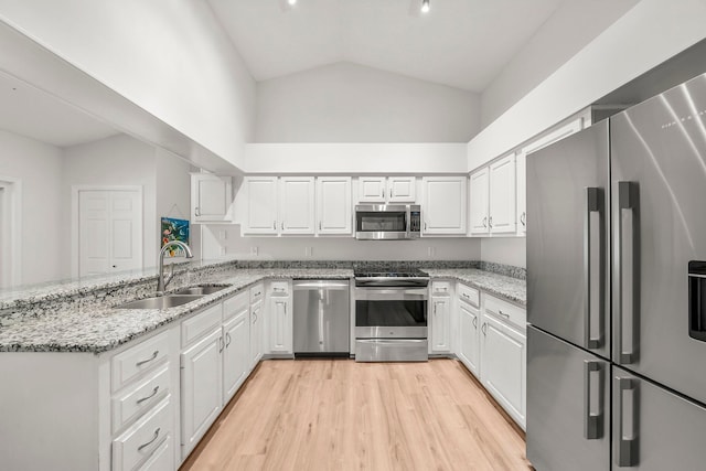 149 Kel Wen Cir, Destin, FL 32541 - kitchen with appliances with stainless steel finishes, a sink, a peninsula, high vaulted ceiling, and white cabinetry