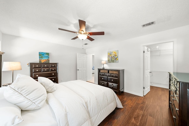 149 Kel Wen Cir, Destin, FL 32541 - bedroom with dark wood finished floors, attic access, ceiling fan, a walk in closet, and baseboards